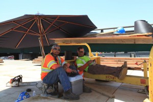 Flatiron Construction employees taking a break in the shade of an umbrella