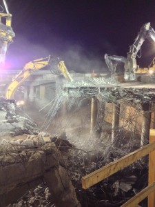 Night photo of a bridge demoltion project showing debris and tractors